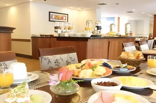 a table with plates of food on top of it at Flat Live Vila Mariana/Ibirapuera (Apto 1002) in Sao Paulo