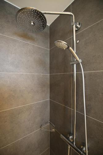 a shower with a shower head in a bathroom at Serenity Waves Villa 27 in Sophtadhes