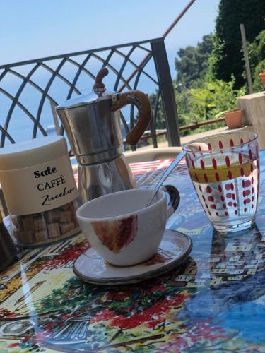 a cup of coffee on a table with a tea kettle at Lemon in the air Family in Pontone