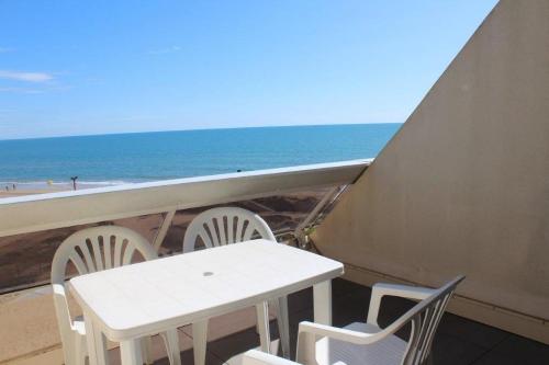d'une table et de chaises sur un balcon donnant sur la plage. dans l'établissement Studio Horizon - Héliopolis AB 408 - Luxe - 2 personnes, au Cap d'Agde