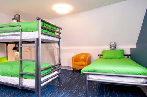 a room with two bunk beds and a chair at YHA South Downs in Lewes