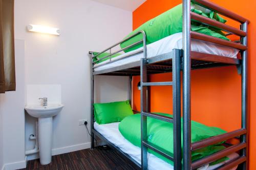 a bunk bed room with an orange and green wall at YHA South Downs in Lewes