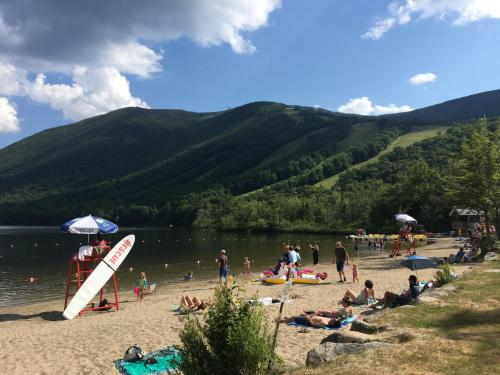 a group of people on a beach near a body of water at B1 NEW Awesome Tiny Home with AC Mountain Views Minutes to Skiing Hiking Attractions in Carroll