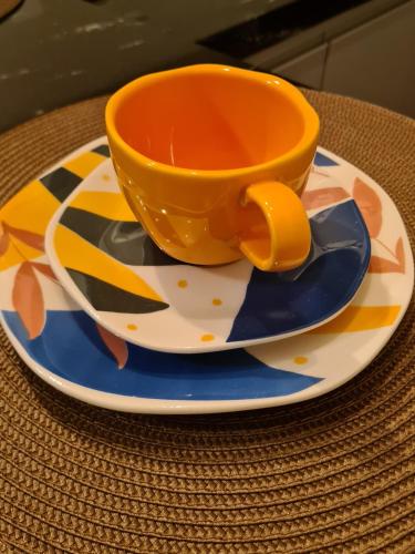 an orange cup sitting on a plate on a table at La Floresta Suites in Campos do Jordão