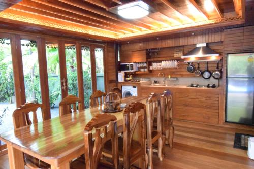 a large kitchen with a wooden table and chairs at Baan Habeebee Resort in Ao Nang Beach