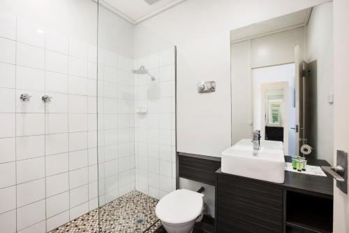 a bathroom with a toilet, sink, and mirror at Nightcap at Sandringham Hotel in Sandringham