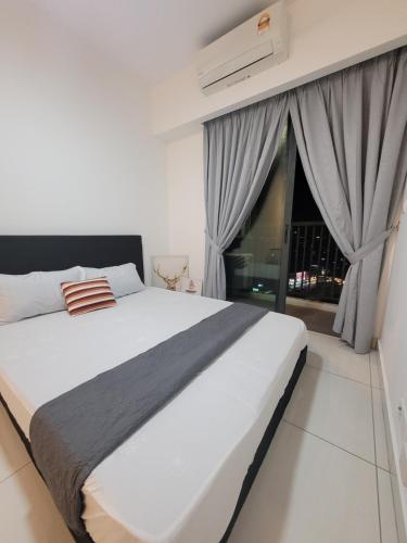 a bedroom with a large white bed and a window at Edumetro Homes in Subang Jaya