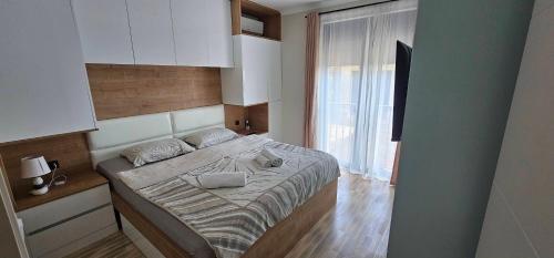 a bedroom with a bed and a large window at Ralux apartman Tivat in Tivat