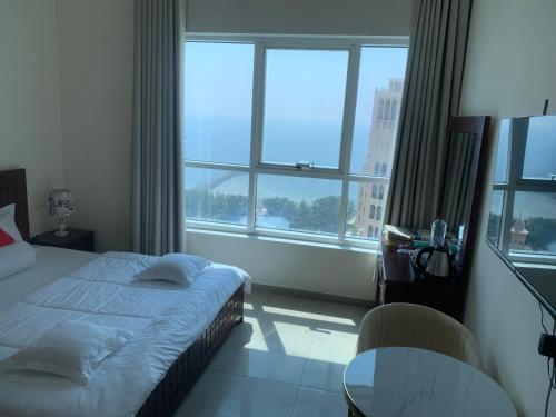 a bedroom with a bed and a large window at Family rooms with beach view in Ajman 