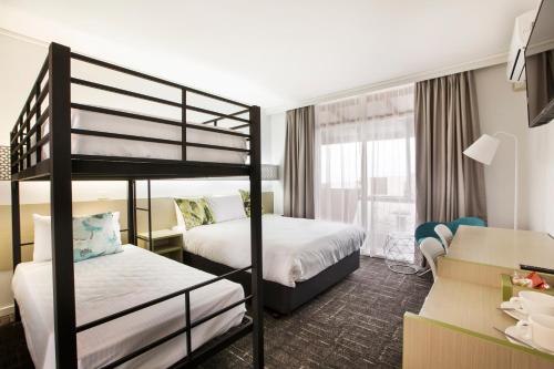 桑德林罕的住宿－桑德靈厄姆奈特卡普酒店，酒店客房设有两张双层床和一张书桌。