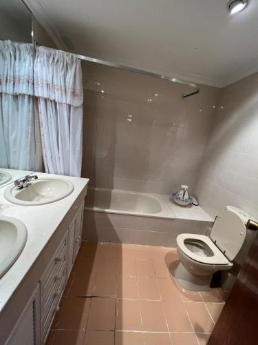 a bathroom with two sinks and a toilet and a tub at Casa sevilla Cavaleri in Mairena del Aljarafe