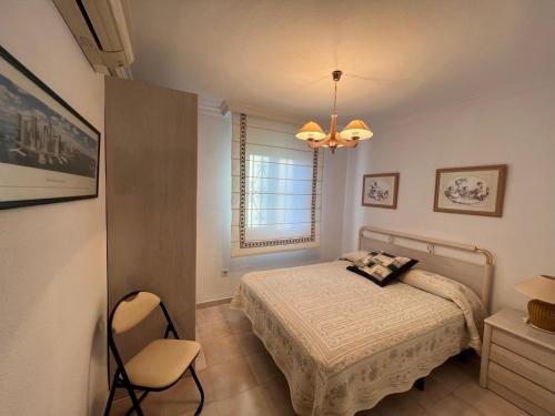 a bedroom with a bed and a chair and a window at Casa sevilla Cavaleri in Mairena del Aljarafe