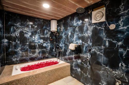 ジャイサルメールにあるDesert Heritage Luxury Camp And Resortの黒いタイル張りの壁のバスルーム(バスタブ付)