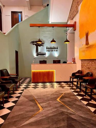 a restaurant with a waiting area with chairs and a table at BaobaBed Lodge, Yangon in Yangon