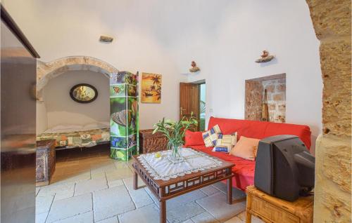 a living room with a red couch and a tv at Trullo 1474 in Ceglie Messapica
