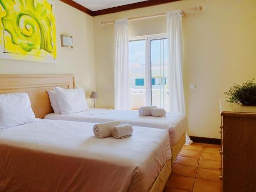 2 camas en una habitación con ventana en Benagil Beach House - Yasmin en Lagoa