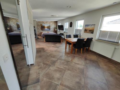 Una habitación con una mesa y sillas y un dormitorio. en FeWo Banter Eck Mini Loft, en Wilhelmshaven