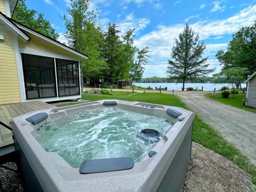 a hot tub in the backyard of a house at 91WR Lake vibes and views at this waterfront home in the the White Mountains! Rest, relax, explore! in Whitefield