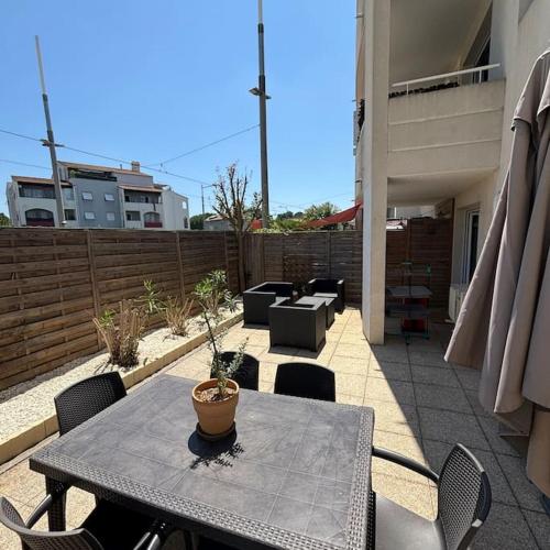 a patio with a table and chairs on a balcony at appartement terrasse et piscine in Montpellier