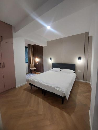 1 dormitorio con 1 cama blanca grande y suelo de madera en Modern Living Apartments, en Skopje