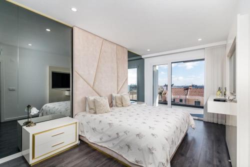 a bedroom with a large bed and a large window at Prime House Lisbon in Famões