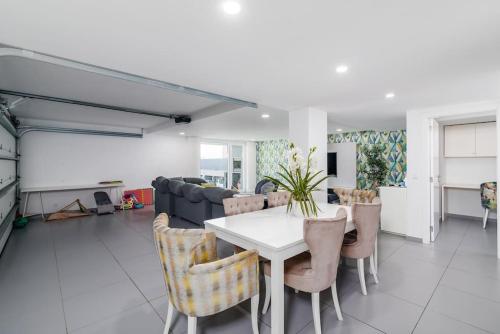 a dining room with a white table and chairs at Prime House Lisbon in Famões