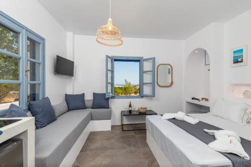 a white living room with a couch and a table at Aitheras Luxury Suites in Protorgia