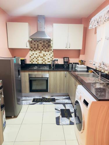 a kitchen with a sink and a stove at Cozy Home Near Wilson Airport & Giraffe Center in Nairobi