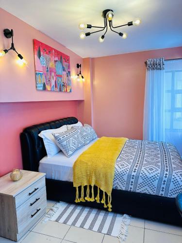 a bedroom with a bed and a pink wall at Cozy Home Near Wilson Airport & Giraffe Center in Nairobi