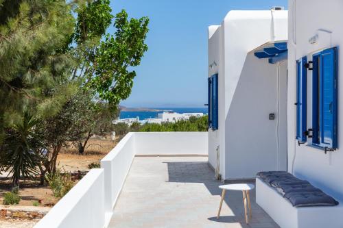 a white house with blue windows and a chair at Aitheras Luxury Suites in Protorgia