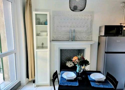 a kitchen with a table with a fireplace and a refrigerator at Grazioso appartamento Red Rose in Moltrasio