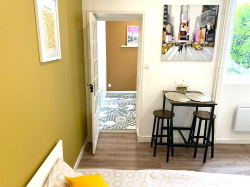 - un couloir avec une table et un tabouret dans la chambre dans l'établissement Appartement Cosy entre la gare et l'hypercentre - tout confort - résidence calme, à Lorient