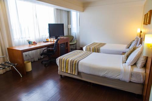 Giường trong phòng chung tại Slaviero Porto Alegre Moinhos