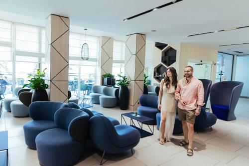 a man and a woman standing in a waiting room at Ilirija Resort Hotel Kornati in Biograd na Moru