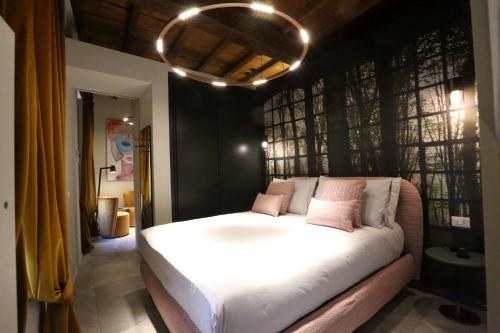 a bedroom with a large white bed with pink pillows at Casa Mandelli in Alba
