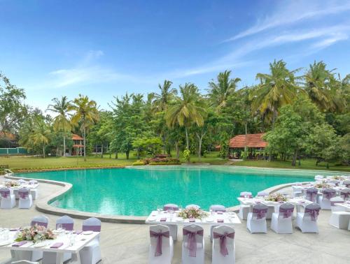 a wedding reception in front of a pool with tables and chairs at Big Banyan Vineyard & Resort in Bengaluru