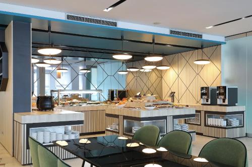 a kitchen with tables and chairs in a restaurant at Ilirija Resort Hotel Kornati in Biograd na Moru