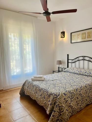 a bedroom with a bed and a ceiling fan at Casa Pedro in Benaoján