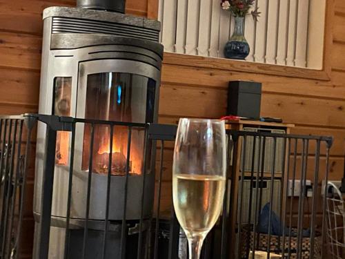 ein Glas Wein am Kamin in der Unterkunft Luxury Peak District lodge, hot tub, log burner, nr lake in Rudyard
