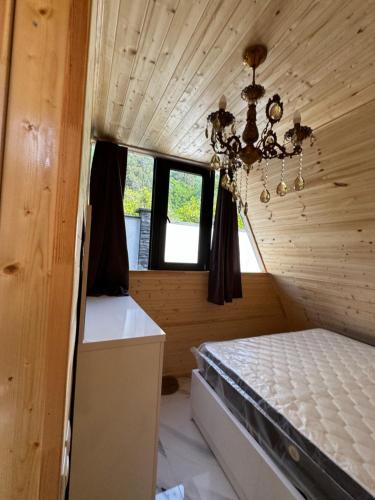 a small room with a bed and a chandelier at Villa Edelweiss in Batumi