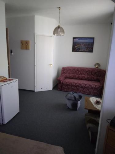 a living room with a red couch and a door at Kokó Panzió in Harkány