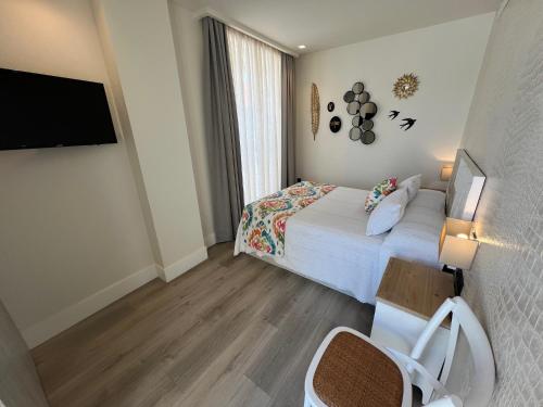 a hotel room with a bed and a flat screen tv at La Puerta de Nerja BOUTIQUE - Adults Recommended in Nerja