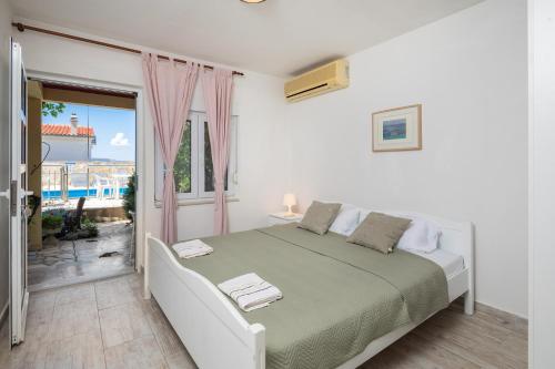 ein weißes Schlafzimmer mit Bett und Balkon in der Unterkunft XXL Apartment - Private Pool in Omiš