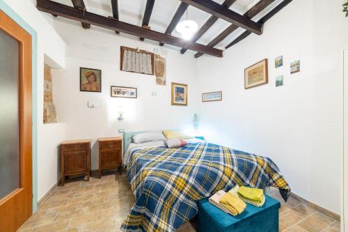 a bedroom with a bed with a plaid blanket at Radici Etrusche Sutri in Sutri