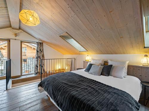 a bedroom with a large bed with a wooden ceiling at Chalet Méribel, 4 pièces, 6 personnes - FR-1-566-20 in Les Allues