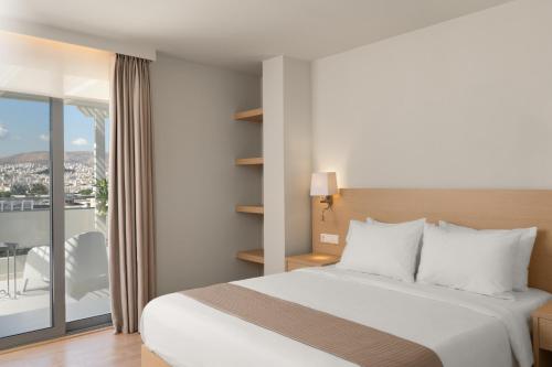 a hotel room with a bed and a balcony at Gallery Central Piraeus Port in Piraeus