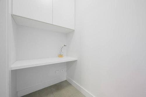 a white shelf in a room with white walls at Olympic Park with View Parking near Train in Sydney