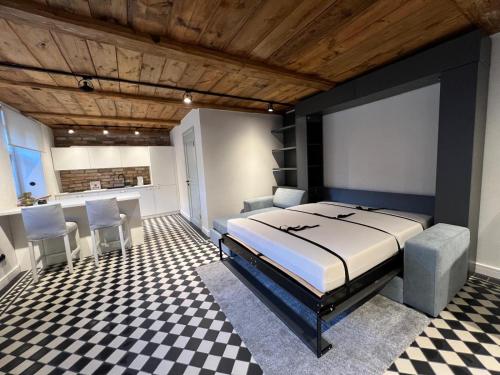 a bedroom with a bed and a checkered floor at Raiņa ielas apartamenti R5 in Kuldīga