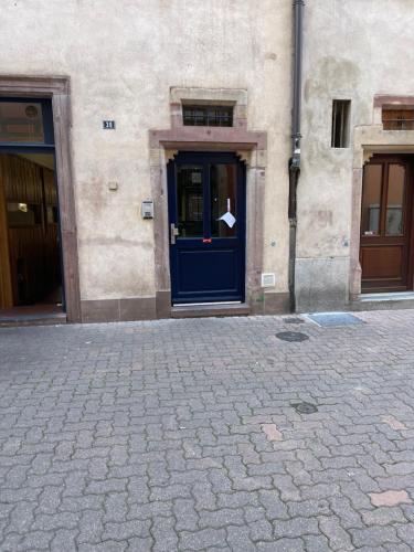 un bâtiment avec une porte bleue avec un papier blanc dessus dans l'établissement Le Drapier charmant 2P Centre ville, à Strasbourg