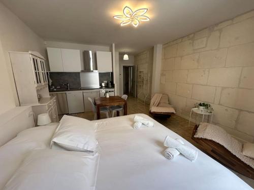 une chambre avec un lit blanc avec des serviettes dessus dans l'établissement Le flamant rose Arles centre, à Arles